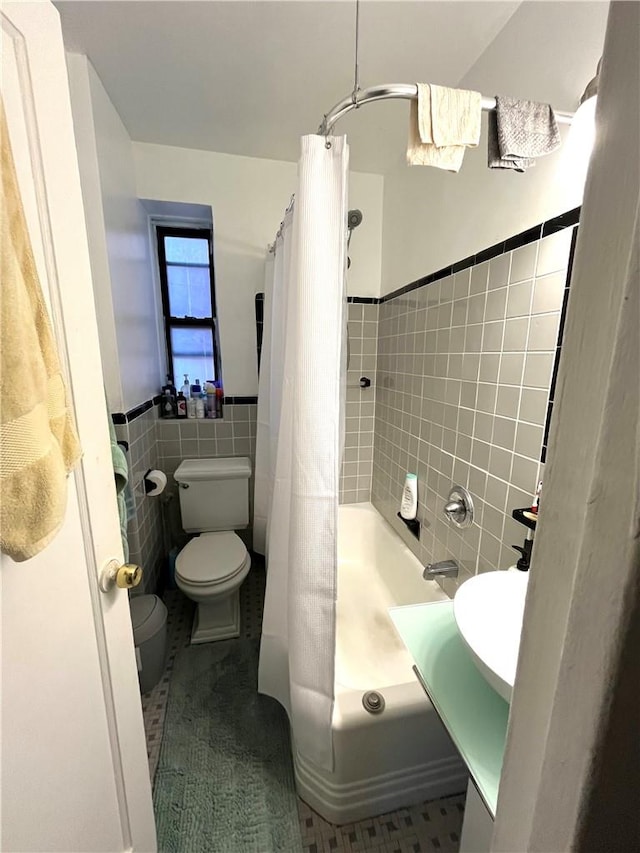 full bathroom featuring tile patterned floors, sink, toilet, shower / bathtub combination with curtain, and tile walls