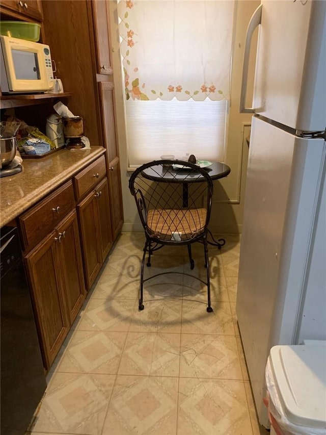 kitchen featuring black dishwasher and fridge