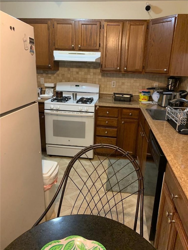 kitchen with sink, white appliances, and backsplash