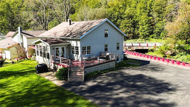 rear view of house with a deck and a lawn