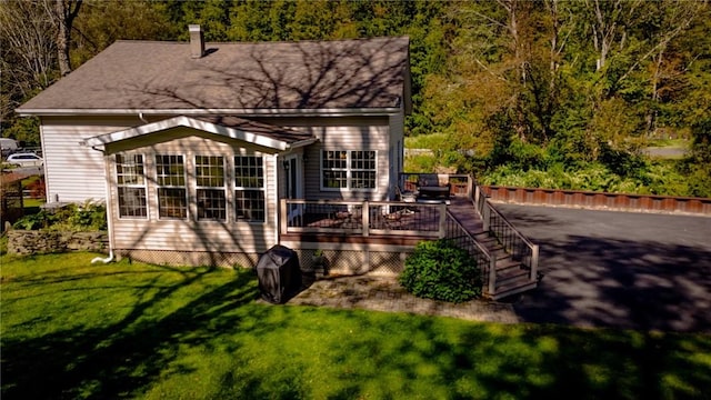 rear view of house featuring a yard and a wooden deck