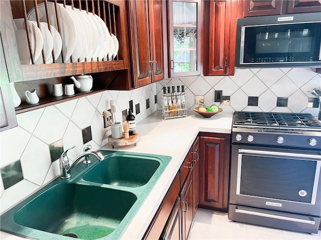 kitchen with appliances with stainless steel finishes, tasteful backsplash, and sink
