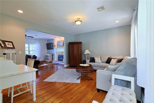 living room featuring dark hardwood / wood-style flooring and ceiling fan