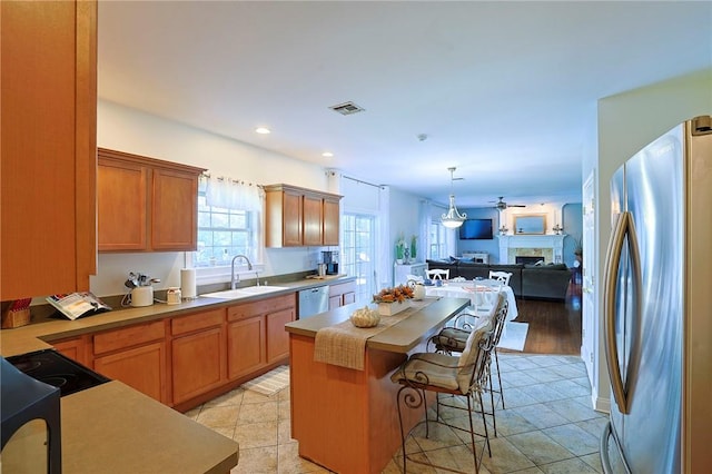 kitchen featuring sink, stainless steel appliances, light hardwood / wood-style flooring, a breakfast bar area, and a kitchen island