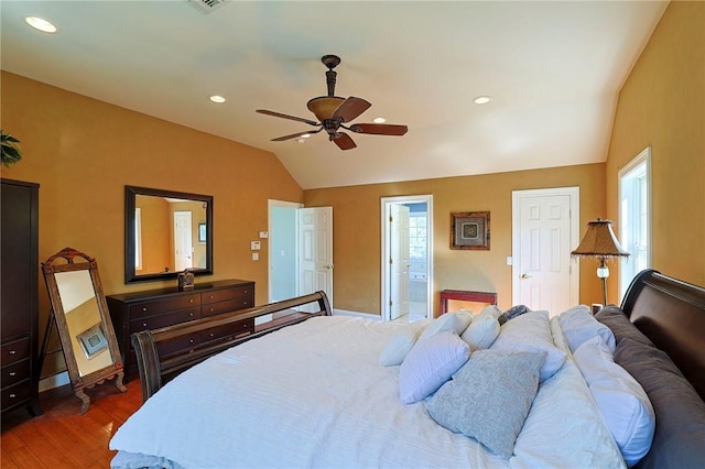 bedroom featuring dark hardwood / wood-style flooring, ensuite bathroom, vaulted ceiling, and ceiling fan