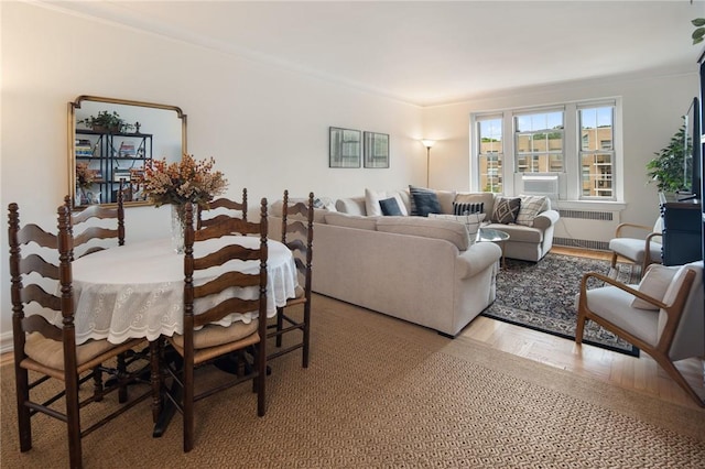 dining space featuring radiator heating unit, light hardwood / wood-style floors, and ornamental molding