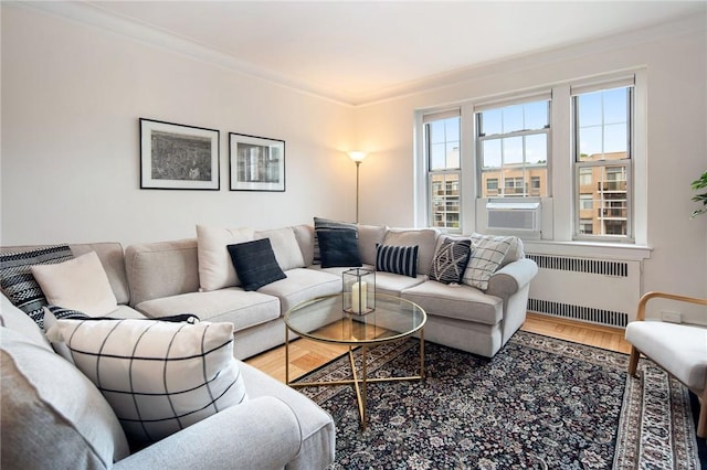 living room with hardwood / wood-style flooring, cooling unit, radiator heating unit, and ornamental molding