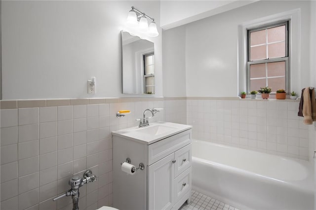 bathroom featuring a washtub, vanity, tile patterned flooring, and tile walls