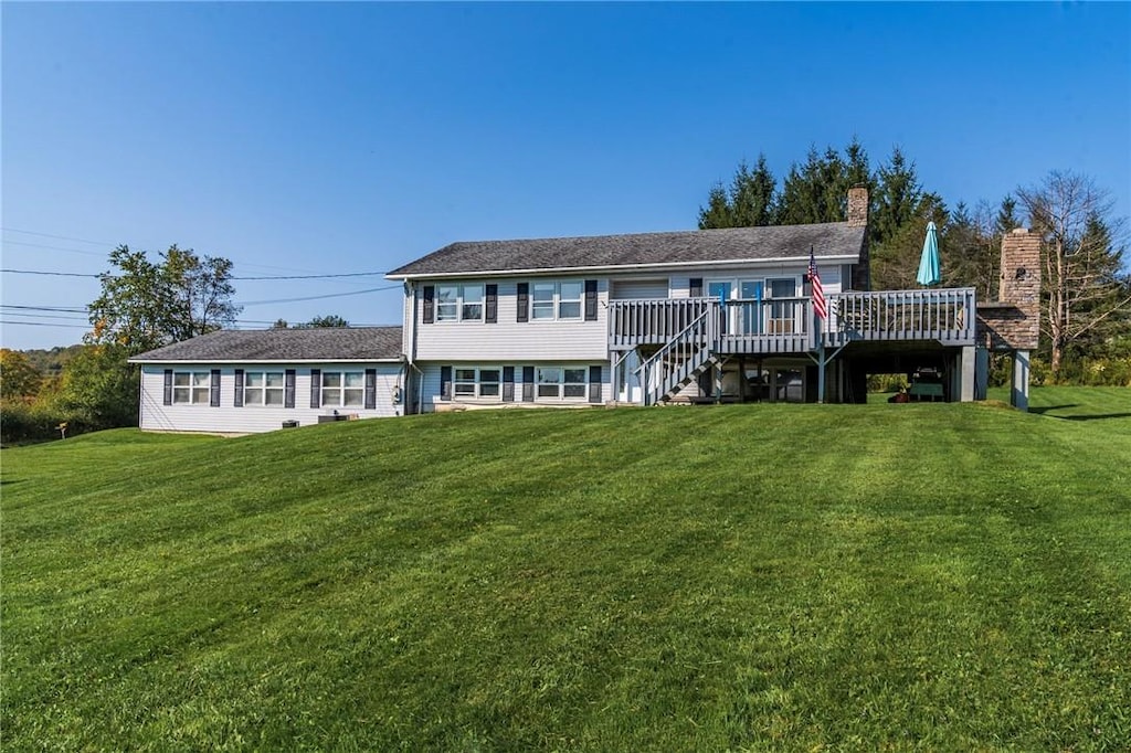 rear view of house with a lawn and a wooden deck