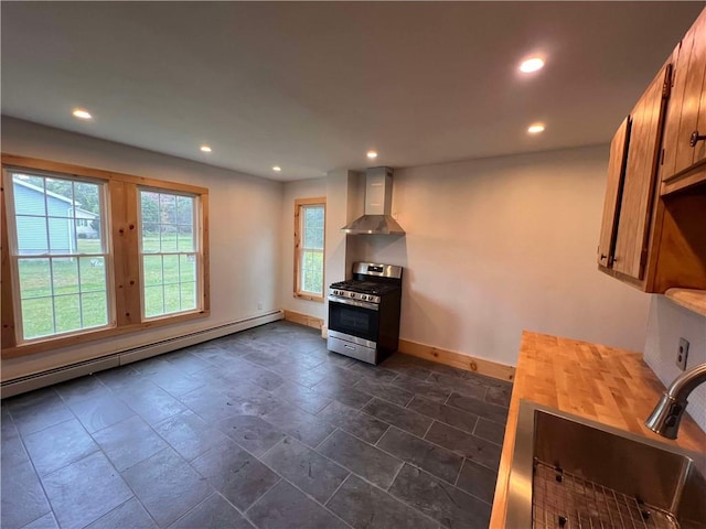 kitchen with sink, stainless steel range with gas cooktop, baseboard heating, and wall chimney range hood