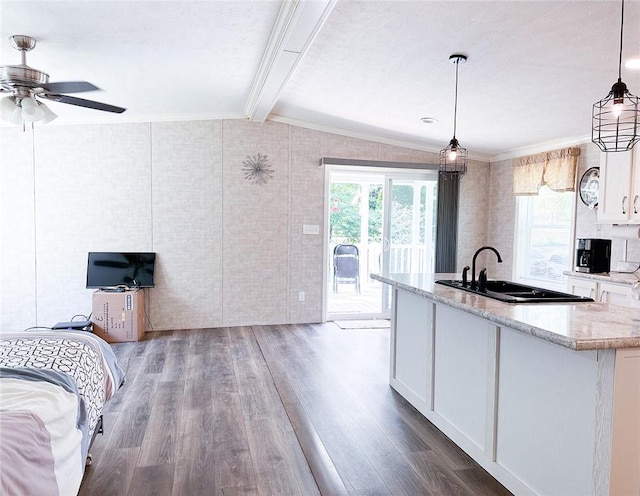 kitchen featuring white cabinets, decorative light fixtures, vaulted ceiling with beams, and wood-type flooring