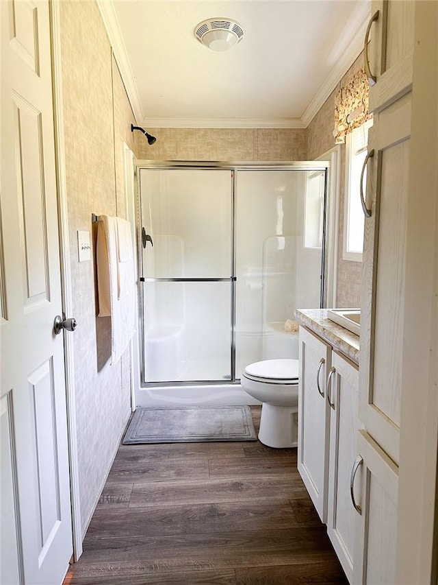 bathroom featuring wood-type flooring, vanity, toilet, and crown molding