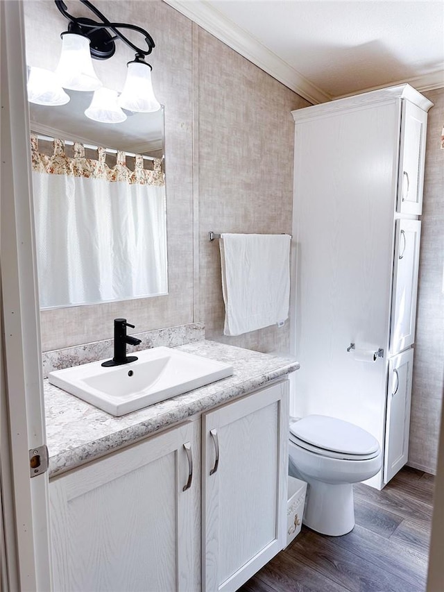 bathroom with a shower with curtain, vanity, crown molding, hardwood / wood-style flooring, and toilet