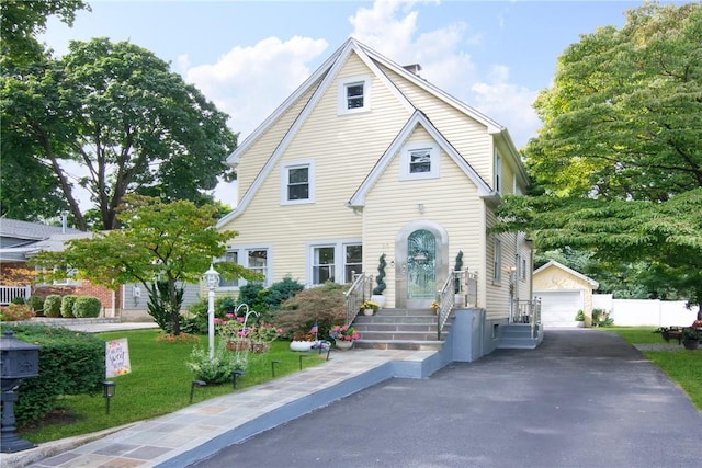 view of front of home with a front lawn, an outdoor structure, and a garage