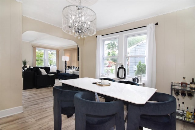 dining room featuring ornamental molding, light hardwood / wood-style flooring, and a notable chandelier