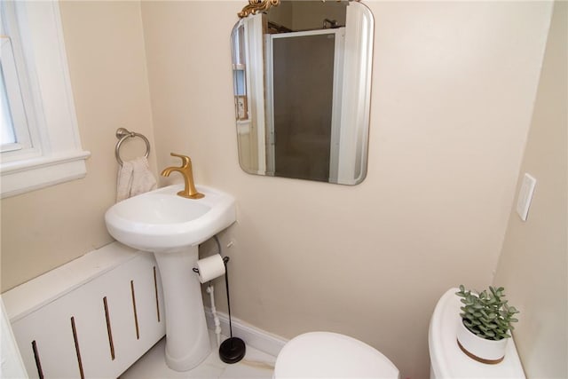 bathroom featuring tile patterned floors, a shower with shower door, and toilet