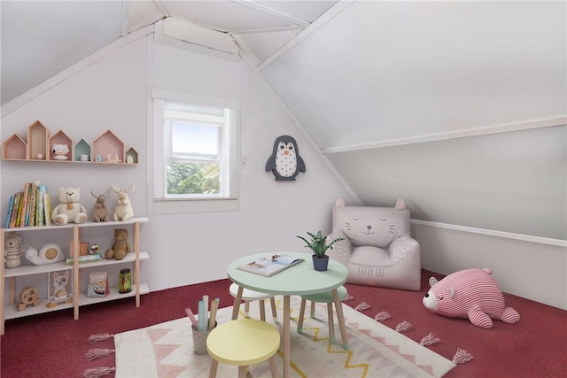 recreation room featuring dark carpet and vaulted ceiling