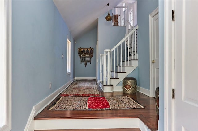 entryway with dark hardwood / wood-style floors and vaulted ceiling