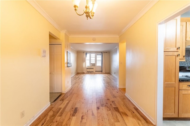 corridor featuring crown molding, light hardwood / wood-style floors, and an inviting chandelier