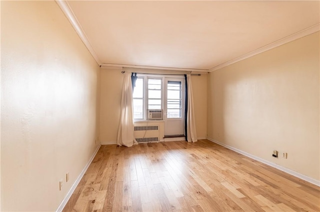 spare room featuring light hardwood / wood-style floors, radiator heating unit, crown molding, and cooling unit