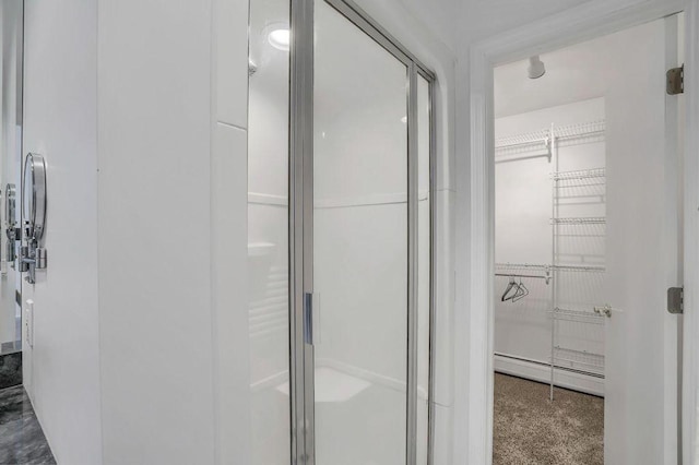 bathroom with a baseboard heating unit and walk in shower