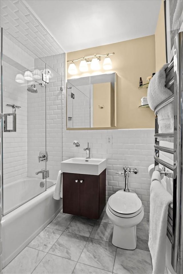 2575 Palisade Ave Unit 2G, Bronx, NY 10463 - full bath with shower / bath combination with glass door, vanity, tile walls, marble look tile flooring, and toilet