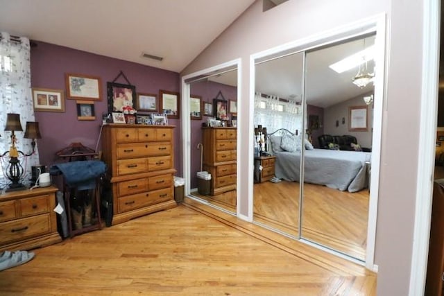 bedroom with lofted ceiling and wood-type flooring