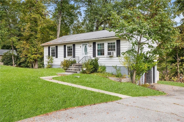 view of front of house featuring cooling unit, a garage, and a front yard