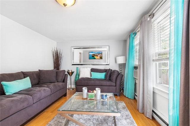 living room featuring a baseboard heating unit and light hardwood / wood-style flooring