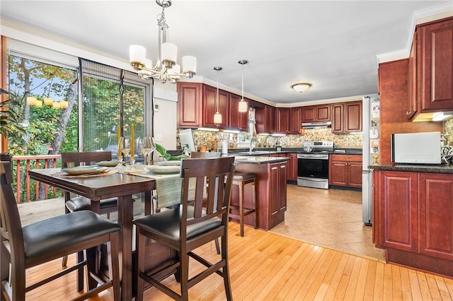 kitchen with crown molding, sink, an inviting chandelier, hanging light fixtures, and stainless steel range with electric cooktop