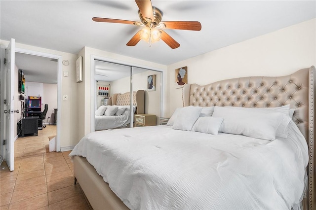 tiled bedroom featuring ceiling fan and a closet