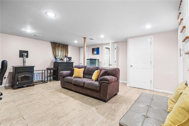 living room featuring light hardwood / wood-style floors and a wood stove