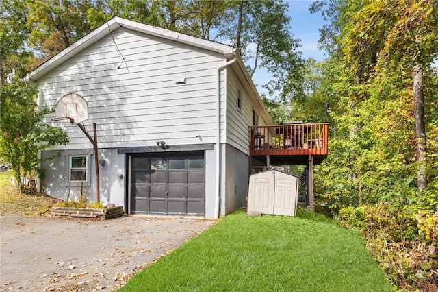 view of home's exterior with a lawn, a storage unit, a garage, and a deck