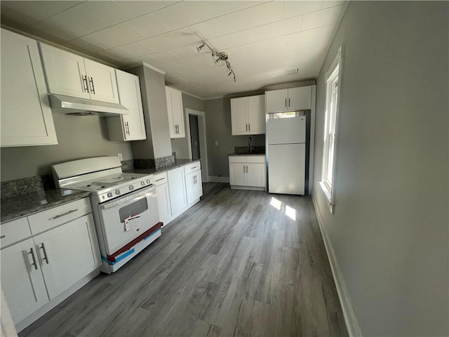 kitchen with rail lighting, dark stone countertops, white appliances, white cabinets, and hardwood / wood-style flooring