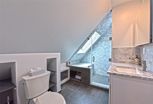 bathroom with vanity, tile patterned floors, a skylight, toilet, and walk in shower