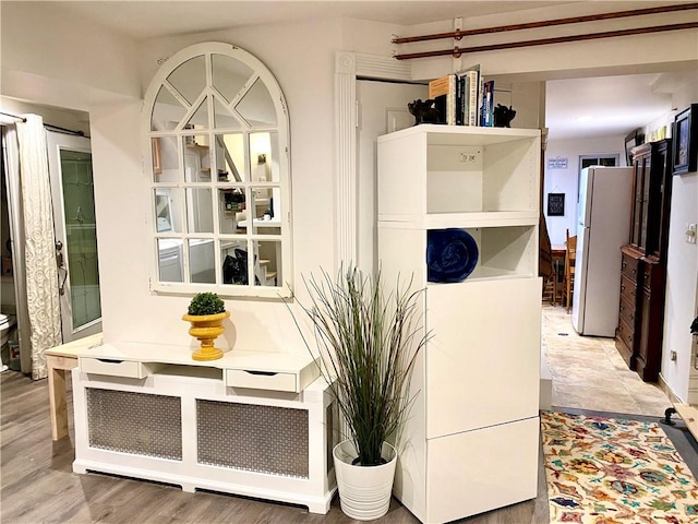 room details featuring white refrigerator and wood-type flooring