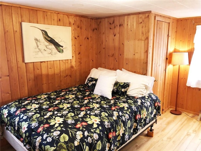 bedroom featuring wooden walls and wood-type flooring