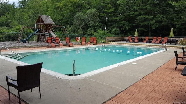 view of swimming pool featuring a playground and a patio