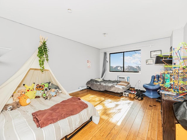 bedroom with a wall unit AC and hardwood / wood-style flooring