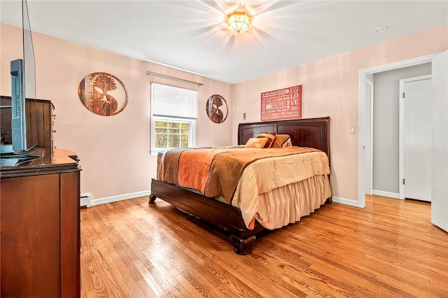 bedroom featuring light hardwood / wood-style floors and a baseboard heating unit