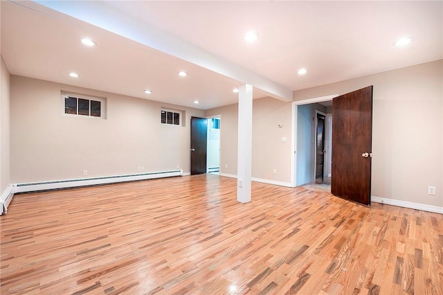 empty room featuring light wood-type flooring and baseboard heating