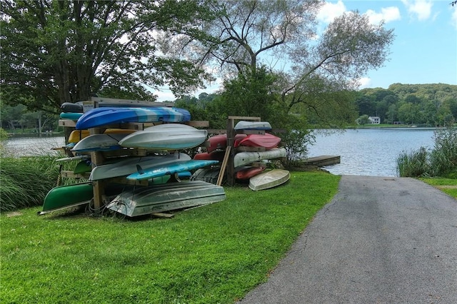 view of dock featuring a lawn and a water view