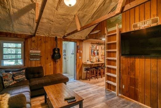 living room featuring hardwood / wood-style floors, lofted ceiling, and wood walls