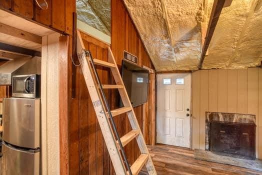 interior space with wooden walls, wood-type flooring, and lofted ceiling