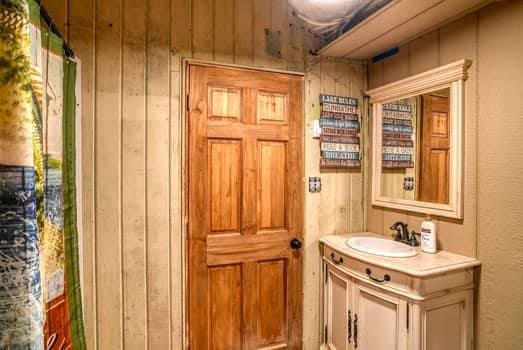 bathroom featuring vanity and wood walls