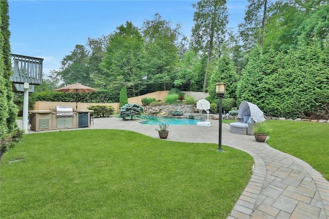 view of swimming pool with a yard, an outdoor kitchen, grilling area, pool water feature, and a patio area