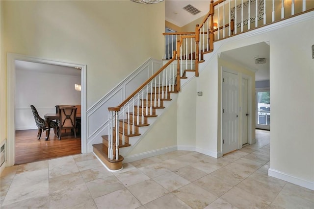 staircase featuring wood-type flooring and high vaulted ceiling