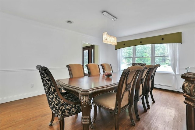 dining room with hardwood / wood-style floors and baseboard heating