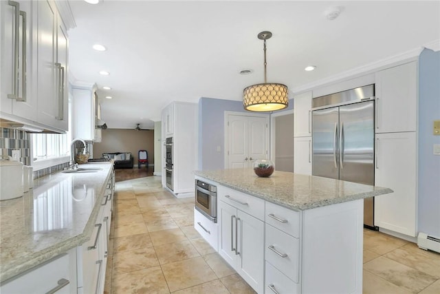 kitchen featuring white cabinets, decorative light fixtures, and stainless steel appliances