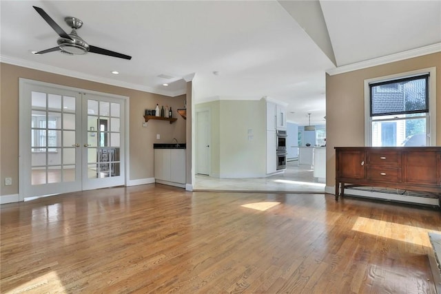 unfurnished living room featuring french doors, light hardwood / wood-style flooring, ceiling fan, ornamental molding, and baseboard heating